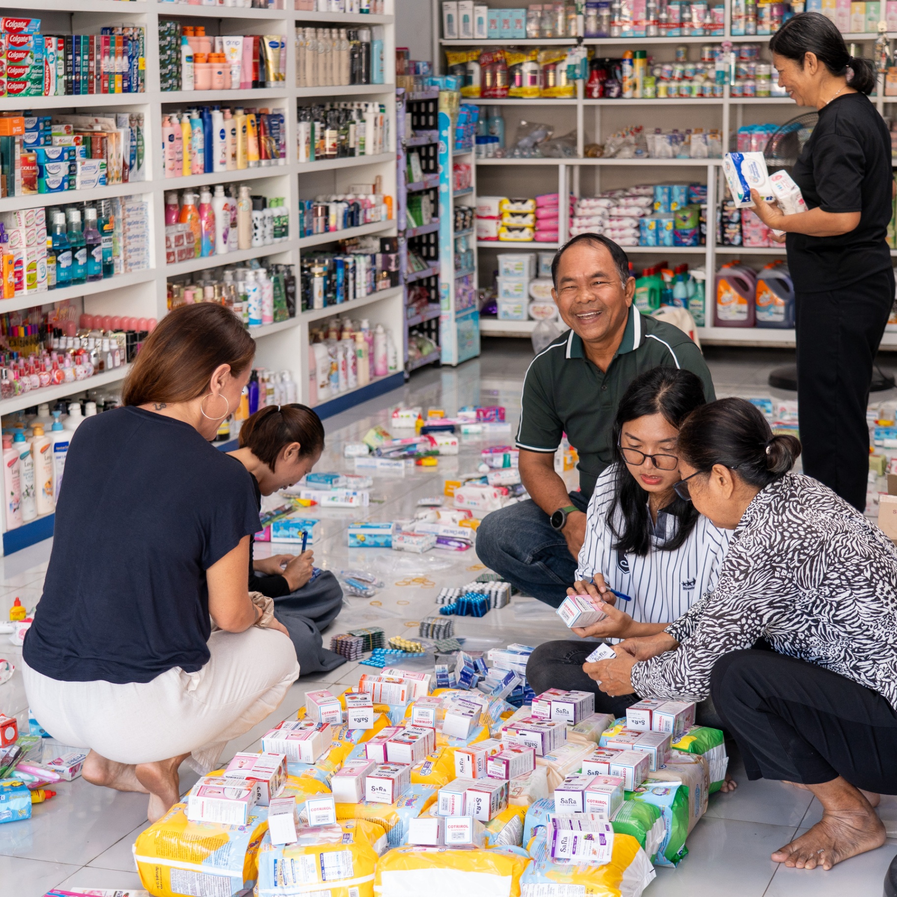Community volunteers work alongside EDGE Worldwide to prepare relief essentials for displaced Cambodian families